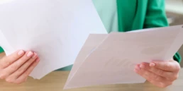 manager holding many documents hands while sitting working desk business woman looks